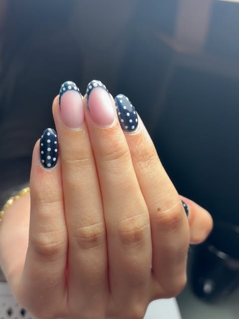Korte nagels in donkerblauw met witte stippen en een French