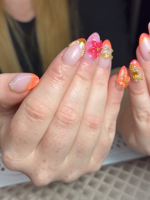 Amandelnagels in koraal en roze met bloemetjes en gouden details